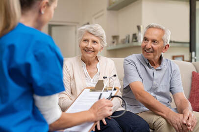 Nurse sitting with elderly couple while filling out questionnaire image 